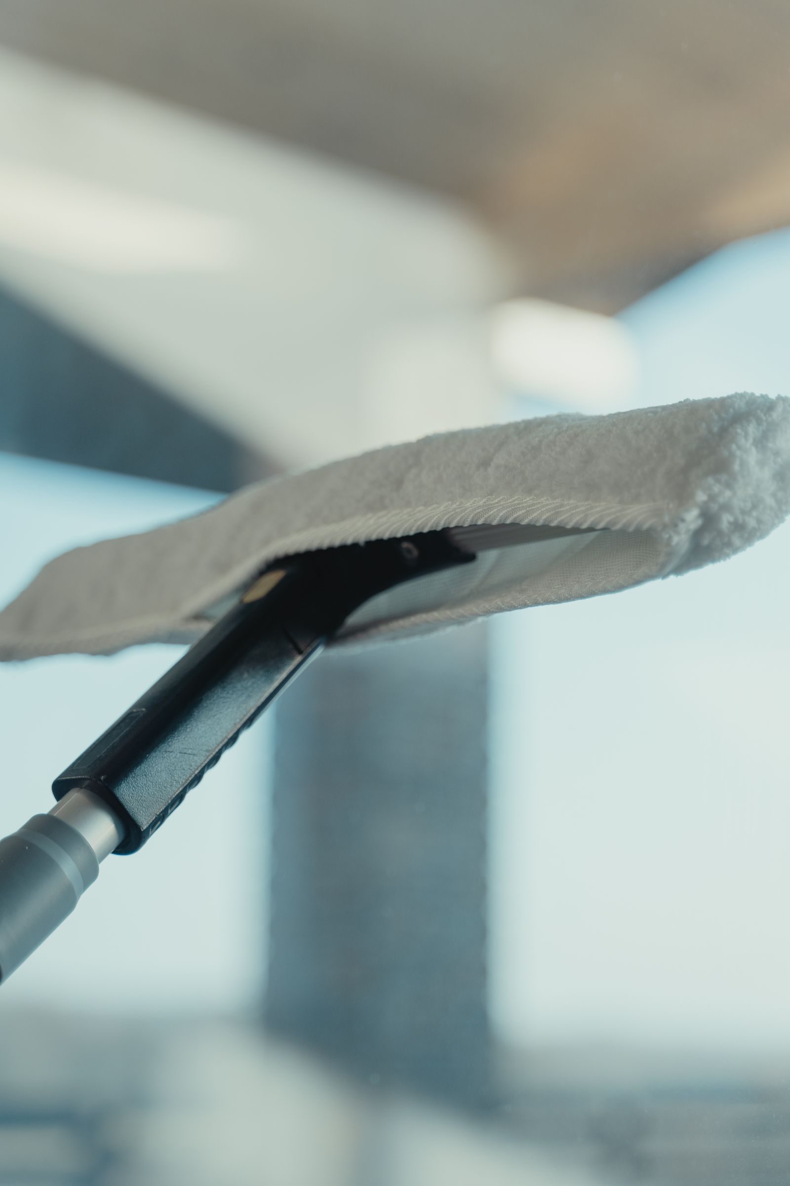 A squeegee pulling across a window leaving glass streak-free